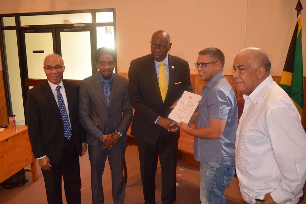 Minister of Health, Dr. Fenton Ferguson (centre) hands over the signed contract for the renovation of the Linstead Hospital Accident and Emergency Department to Alexander Chin of Chin's Construction Limited (2nd right). The Health Minister is joined by Member of Parliament for North West St. Catherine and Minister with Responsibility for Climate Change, Hon. Robert Pickersgill (right), Chairman of the Board of the National Health Fund, Sterling Soares (left) and Chairman of the Board of the South East Regional Health Authority, Dr. Andrei Cooke (2nd left). The contract, which is valued at $76,428,138, was signed at Jamaica House on Tuesday, September 22, 2015.